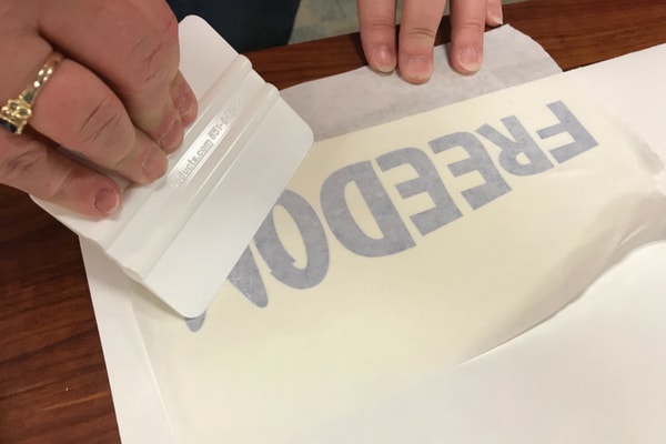 Transfering sign vinyl to application tape with squeegee